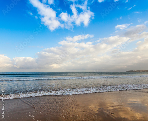 Atlantic ocean coast with waves and bright cloudy sky