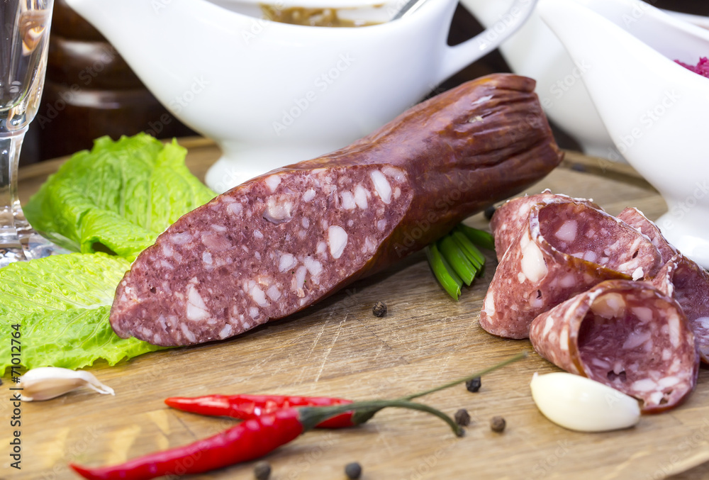 sausages on a wooden plate with vegetables in a restaurant sausages on a wooden plate with vegetables in a restaurant