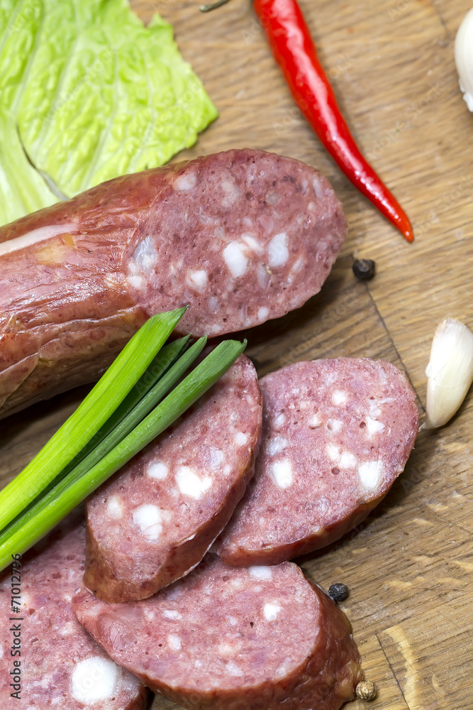 sausages on a wooden plate with vegetables in a restaurant sausages on a wooden plate with vegetables in a restaurant