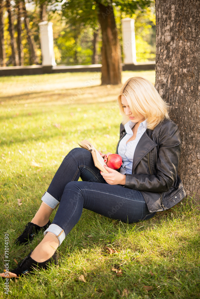 beautiful girl sitting under a tree and reading a book beautiful girl sitting under a tree and reading a book