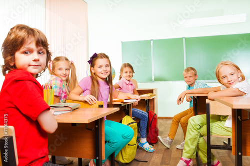 Desk rows with children looking straight