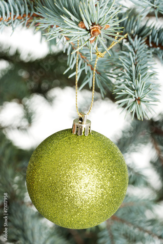 One separated christmas ball handing on a twig.