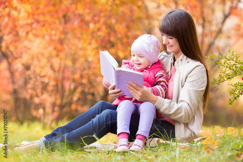 mother reading a book to ki...