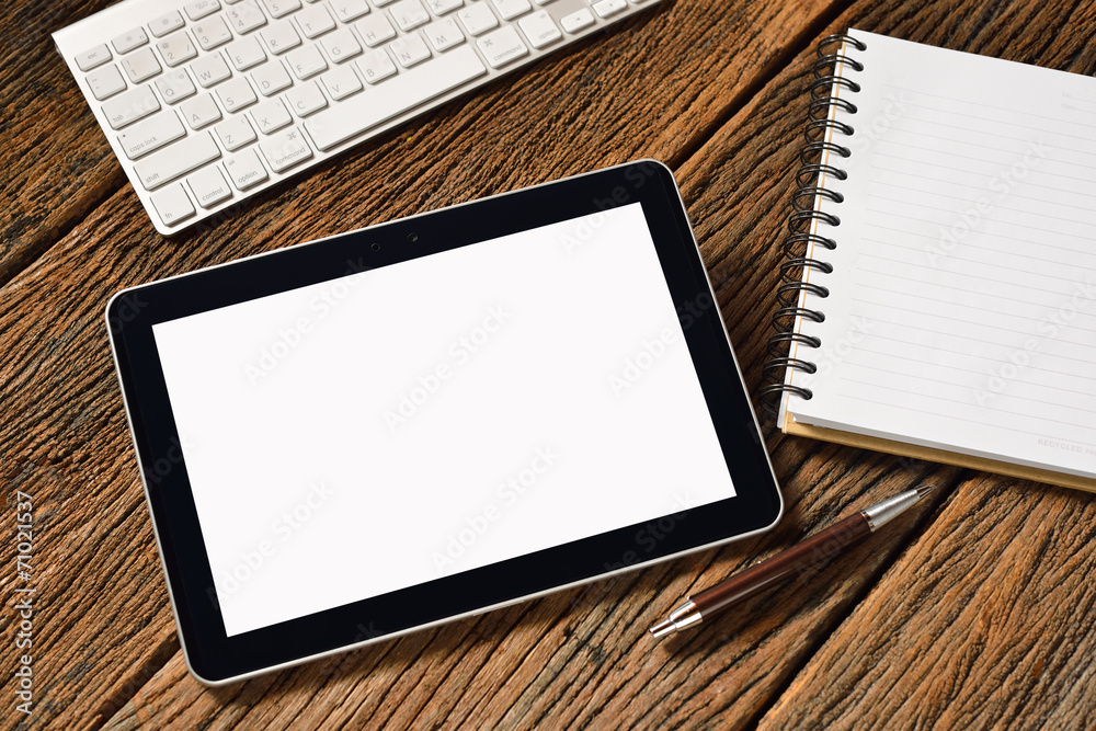 Tablet computer and white papers on old wooden table Tablet computer and white papers on old wooden table