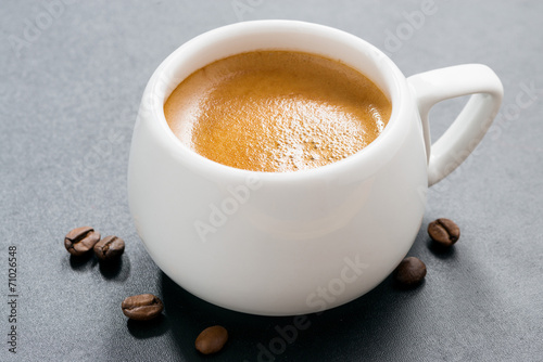 cup of espresso on a dark background and coffee beans, close-up
