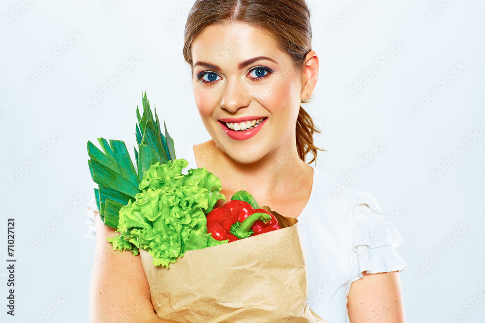 Smiling woman hold bag with green food.