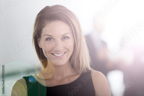 Portrait of attractive businesswoman, people in background