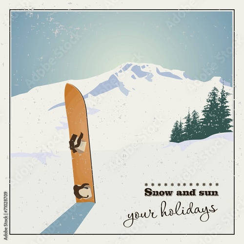 Winter  background. Mountains and old snowboard in the snow