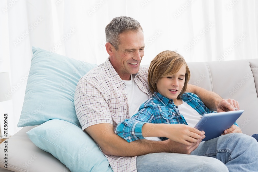 Father with son relaxing on the couch using laptop Father with son relaxing on the couch using laptop