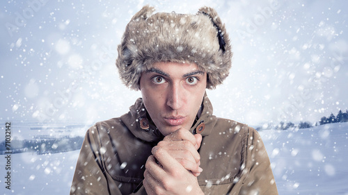 Portrait of young man with eskimo hat and winter  background wit photo