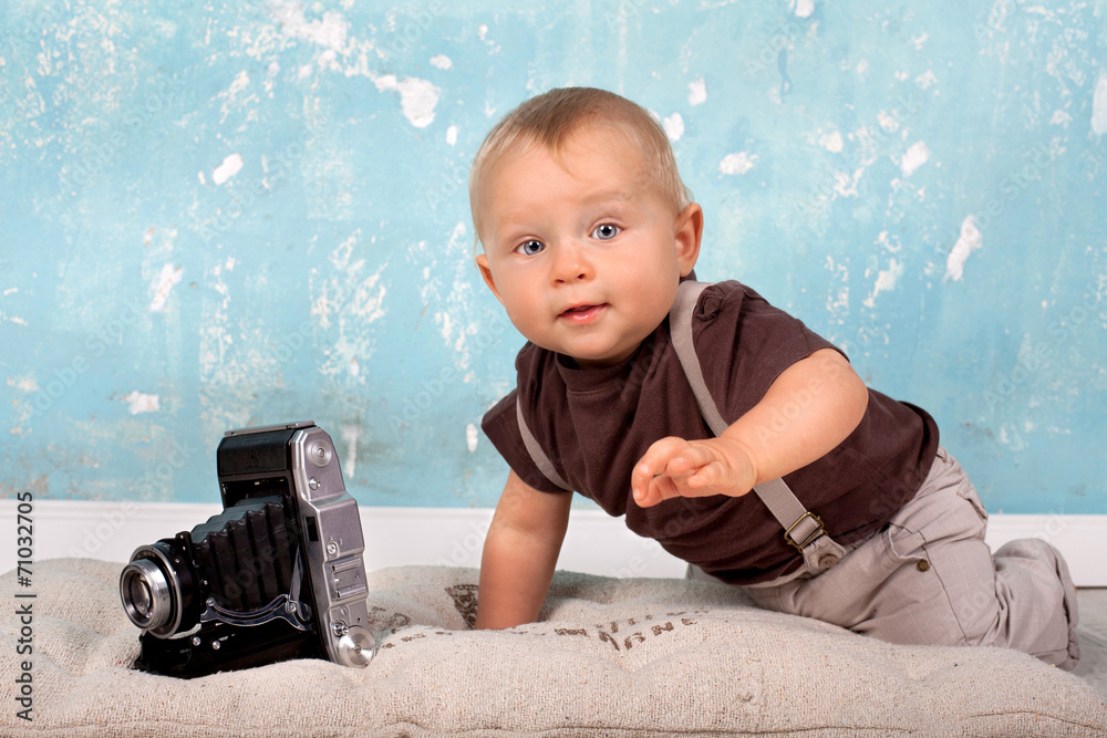 Fototapeta premium neugieriges Baby mit Kamera
