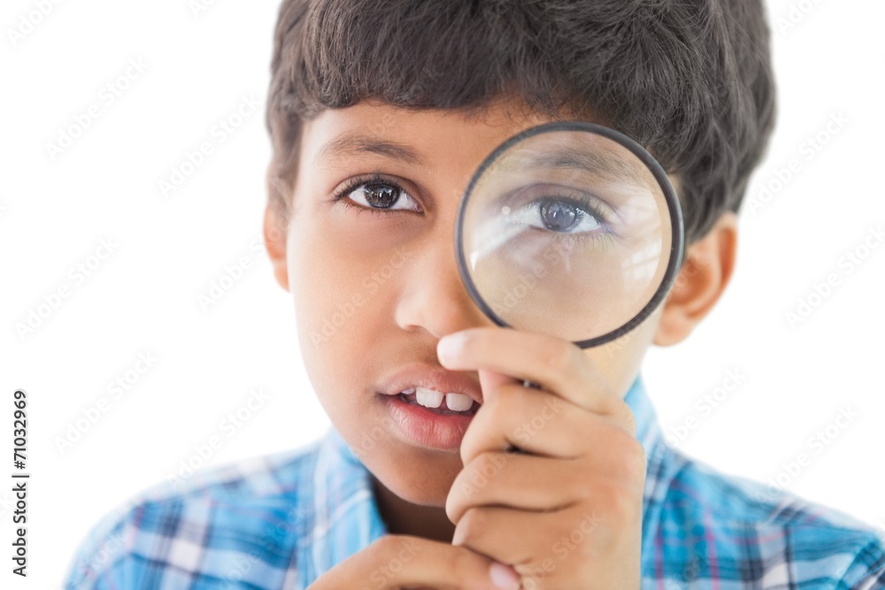 Cute boy looking through a magnifying glass Cute boy looking through a magnifying glass