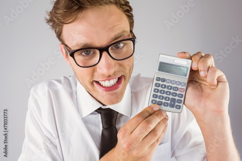 Geeky businessman showing a calculator