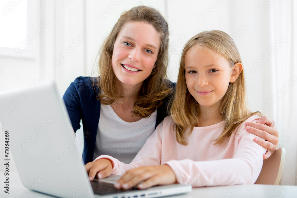 Attractive woman and little sister using laptop Attractive woman and little sister using laptop