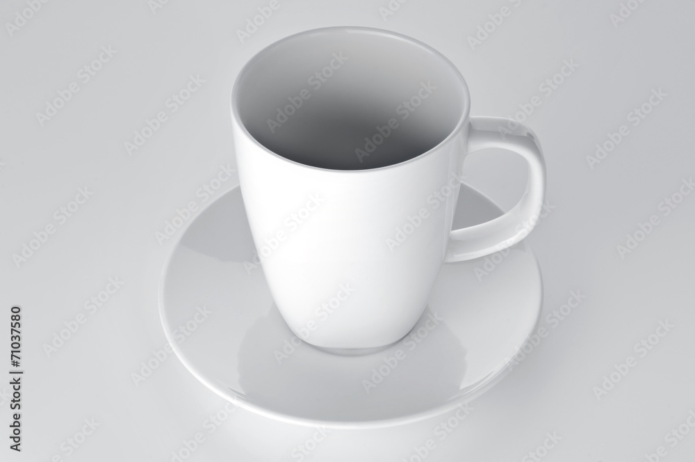 White cup with seucer isolated on gray background White cup with seucer isolated on gray background