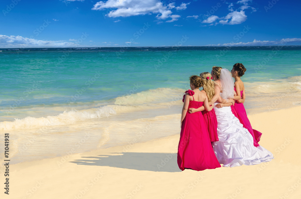 Bride and bridesmaids in pink dresses on Caribbean beach
