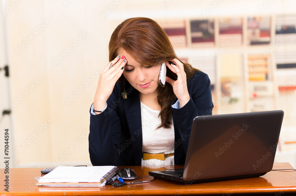 Beautiful young girl working behind a desk with laptop Beautiful young girl working behind a desk with laptop