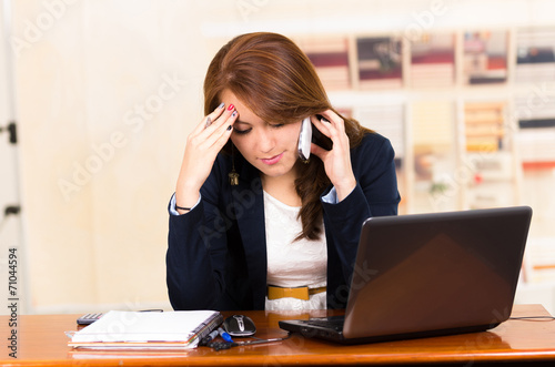 Beautiful young girl working behind a desk with laptop