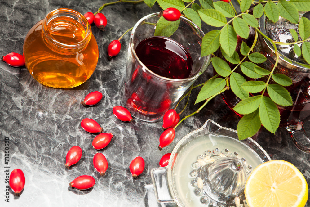 Hagebuttentee mit Honig und Zitrone im Glas Hagebuttentee mit Honig und Zitrone im Glas
