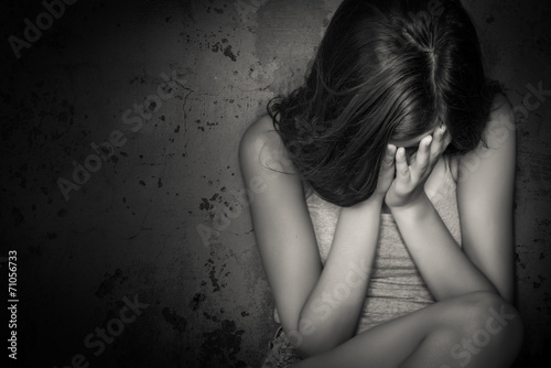 Black and white grunge image of a teen girl crying