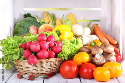 Vegetables in basket on white wooden box background