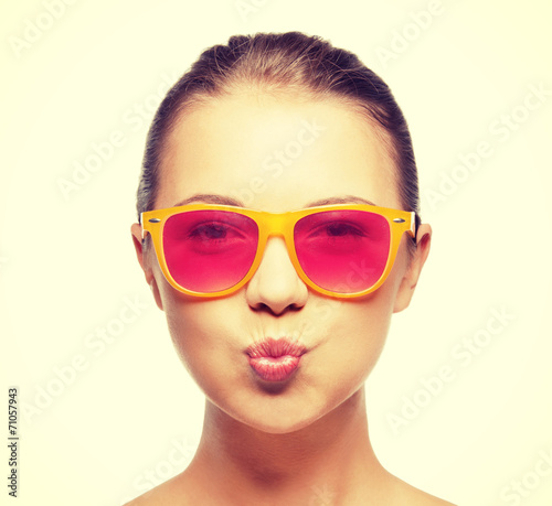 girl in pink sunglasses blowing kiss