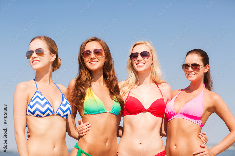 group of smiling young women on beach group of smiling young women on beach