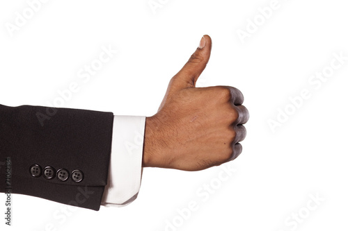 dark skinned hand in suit showing thumb up