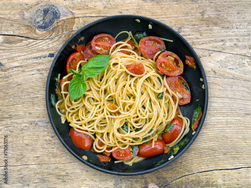 A pan of spaguetti with tomatoes and basil photo