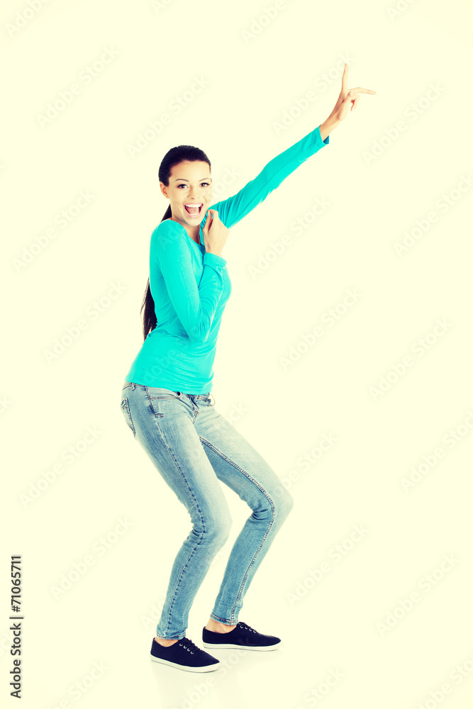 Happy , excited young woman pointing on copy space Happy , excited young woman pointing on copy space