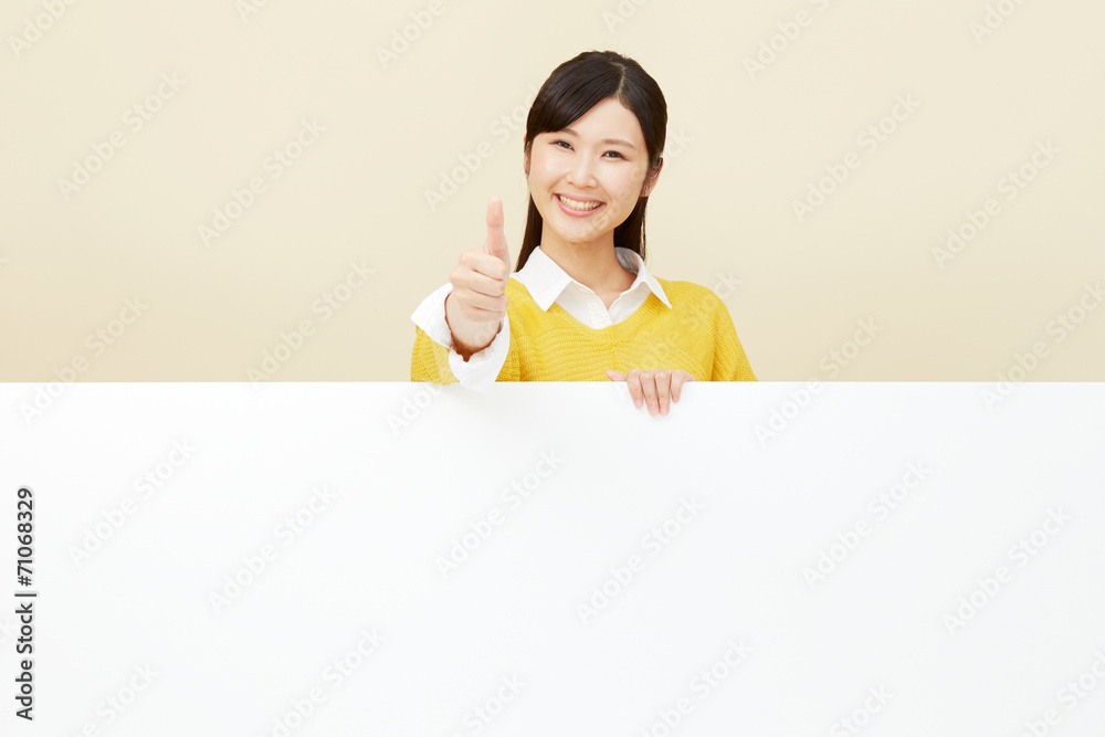 メッセージボードとグッドサインする女性
