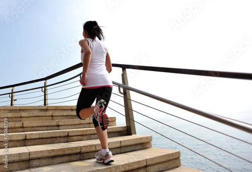 young woman running at seaside stone stairs © lzf