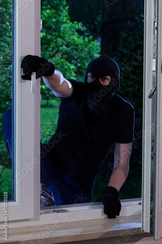Masked man entering the house