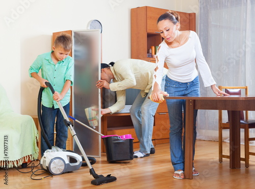 Happy couple and teenager cleaning photo