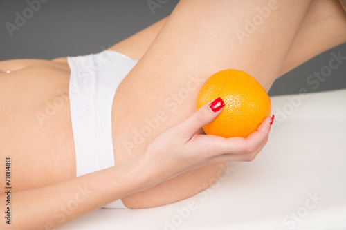 Frau mit einer Orange in der Hand