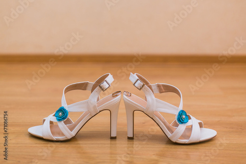 Close up of bride's shoes and gold wedding rings
