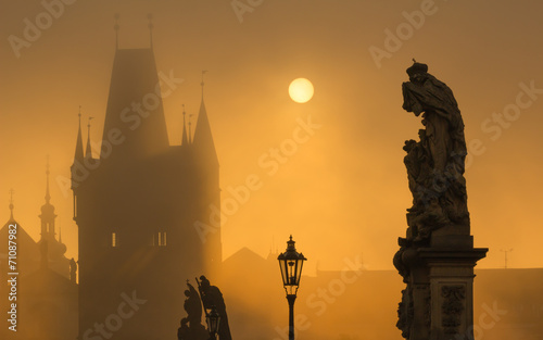 Silhouette of statue on Charles bridge during sunrise
