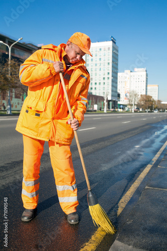 Road sweeper cleaning city street with broom tool