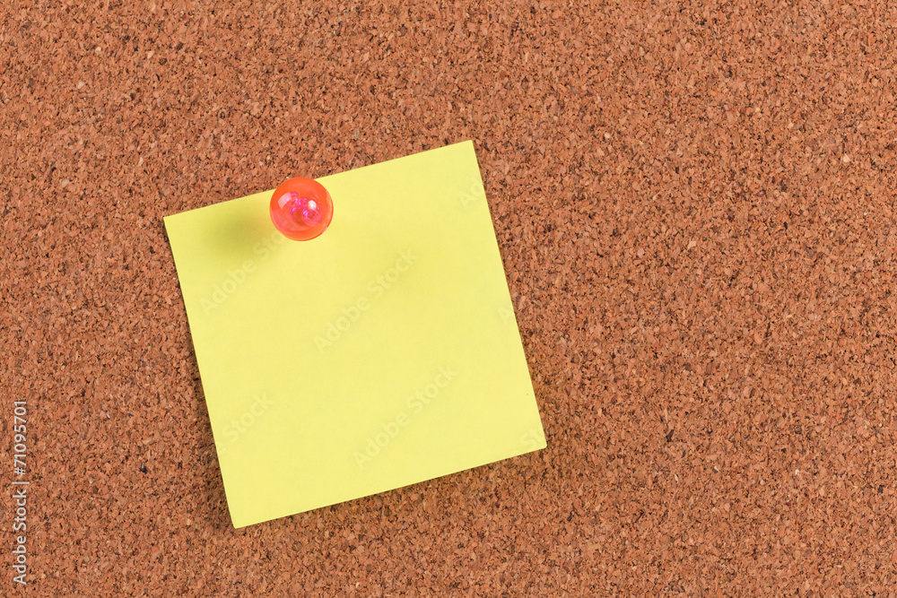yellow reminder sticky note on cork board, empty space for text yellow reminder sticky note on cork board, empty space for text