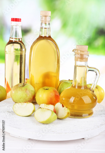 Apple cider vinegar in glass bottles and ripe fresh apples 
