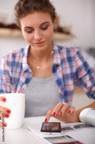 Woman reading mgazine In kitchen at home photo