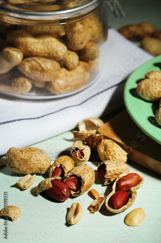 Peanuts and nutcracker on plate, on wooden background