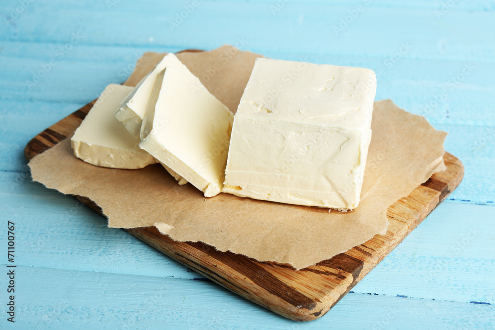 Fresh butter on cutting board, on color wooden background Fresh butter on cutting board, on color wooden background