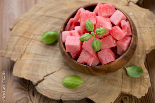 Watermelon cubes over rustic wooden background, above view