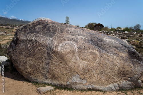 Ancient petroglyph - Hunting with tame snow leopards on the ston photo