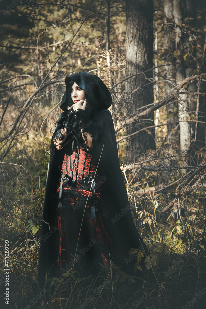 girl vampire in retro dress, in a black cloak, in the forest