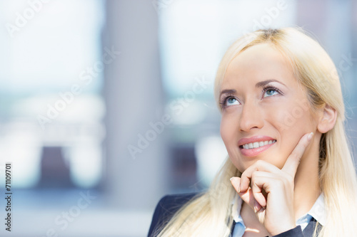 happy young woman looking upwards daydreaming thinking 