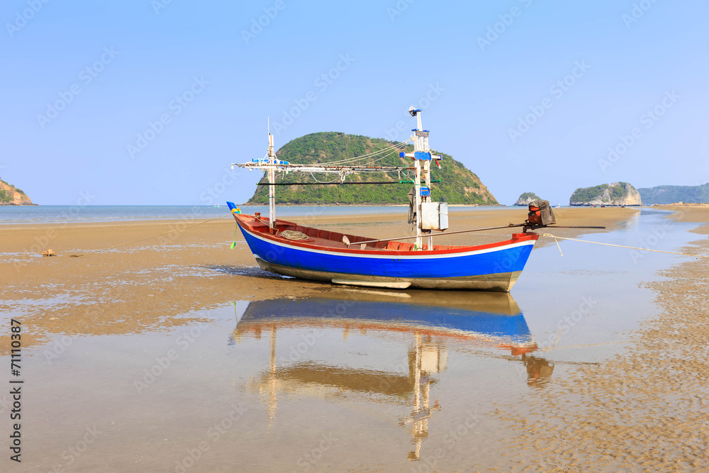 Traditional fishing boat on the beach with reflection