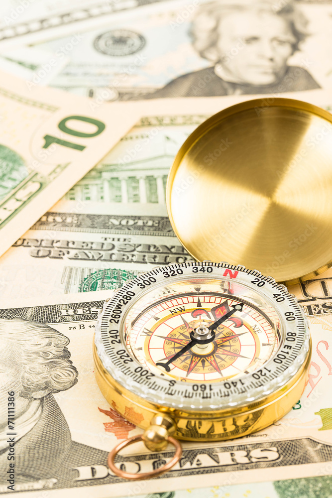 Compass on dollar banknote concept financial direction Compass on dollar banknote concept financial direction