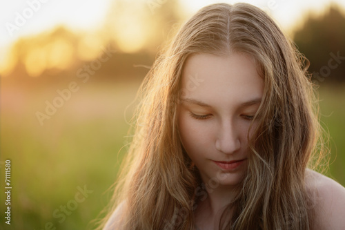 portrait of teen girl in sunset looking down